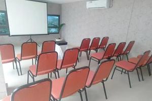 a lecture room with red chairs and a screen at Tera Guest House in Kedaton