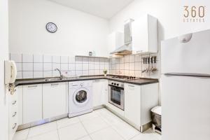 uma cozinha branca com máquina de lavar e secar roupa em Cosy & Stylish 1BR home in The Heart of Gzira by 360 Estates em Il-Gżira