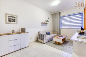 uma sala de estar com um sofá e uma mesa em Cosy & Stylish 1BR home in The Heart of Gzira by 360 Estates em Il-Gżira