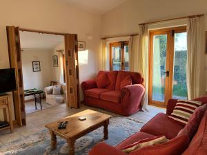 ein Wohnzimmer mit einem roten Sofa und einem Tisch in der Unterkunft The Old Bull Pen in Abergavenny