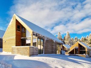 ein Holzhaus im Schnee mit Bäumen in der Unterkunft Feriendorf Wasserkuppe 