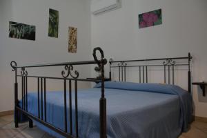 a bedroom with a black bed with a blue blanket at Casale del Gufo in Chiaravalle