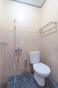 La salle de bains est pourvue d'une douche et de toilettes. dans l'établissement Tera Guest House, à Kedaton