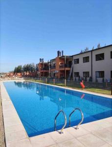 una gran piscina azul frente a algunos edificios en Altos de la Cañada en Mariano Moreno