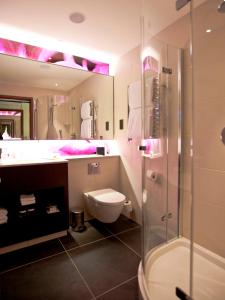 a bathroom with a toilet and a shower and a sink at Hilton London Heathrow Airport Terminal 5 in Hillingdon