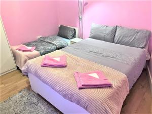 two beds in a pink room with pink towels at Remarkable 1-Bed Apartment in High Wycombe in High Wycombe