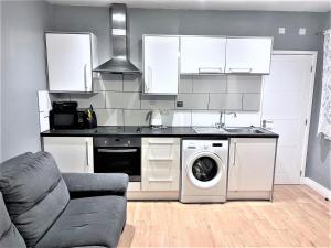 a kitchen with a washing machine and a stove at Remarkable 1-Bed Apartment in High Wycombe in High Wycombe