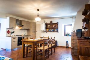 eine Küche mit einem Holztisch und einigen Stühlen in der Unterkunft Casa Ladyhawke in Santo Stefano di Sessanio