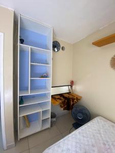 um quarto com um armário branco com prateleiras vazias em MEU CANTINHO: ACONCHEGO E AMOR em Maceió