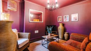 een woonkamer met paarse muren en een bank en een tafel bij Perfect for Business Guests or Leisure in Hough Green