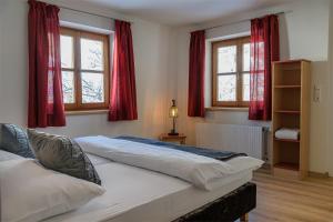een slaapkamer met 2 bedden en 2 ramen bij Alpen-Nest Großarl in Grossarl