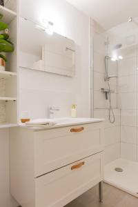 a white bathroom with a sink and a shower at Delalauret Apartment - Vannes Centre in Vannes