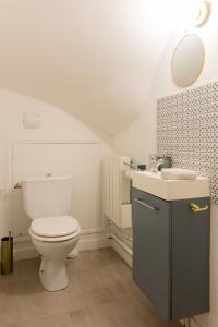 a white bathroom with a toilet and a sink at Delalauret Apartment - Vannes Centre in Vannes