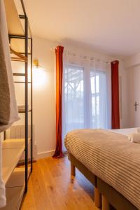 a bedroom with a bed and a window at Delalauret Apartment - Vannes Centre in Vannes