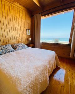 a bedroom with a bed and a large window at Punta de Choros Lodge in Punta de Choros