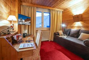 a living room with a couch and a table at Hôtel Au Chamois d'Or by Les Etincelles in L'Alpe-d'Huez