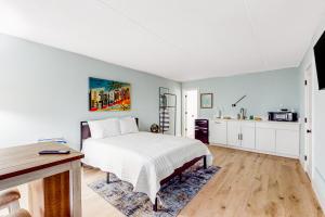 a bedroom with a white bed and a kitchen at Capri 108 in Marco Island