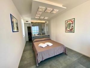 1 dormitorio con 1 cama con 2 toallas en Marina Bay Beach Hotel, en Peschici