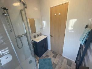 a bathroom with a shower and a sink and a mirror at Luxury Lakeside Lodge L1 with hot tub situated at Tattershall Lakes Country Park in Tattershall +25 photos