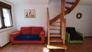 ein Wohnzimmer mit einem Sofa und einer Treppe in der Unterkunft Apartamentos Mobison in Salinas de Bielsa