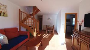 ein Wohnzimmer mit einem Sofa und einer Treppe in der Unterkunft Apartamentos Mobison in Salinas de Bielsa