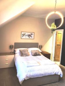 a bedroom with a large bed with white sheets at Sunbeams and ice creams in Scarborough