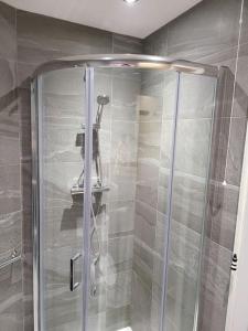 a shower with a glass door in a bathroom at Sunbeams and ice creams in Scarborough