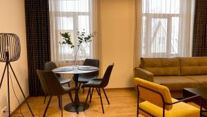 sala de estar con mesa, sillas y sofá en Kastani Factory Apartments, en Tartu