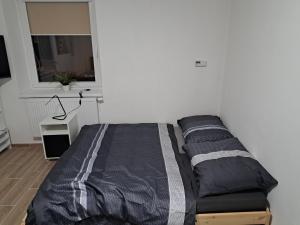a bed sitting in a room with a window at Penzion Labužník in Lovosice