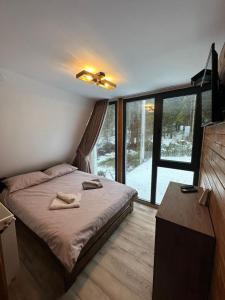 ein Schlafzimmer mit einem Bett und einem großen Fenster in der Unterkunft Cabana Cerbului in Cluj-Napoca