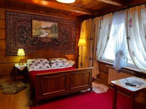 ein Schlafzimmer mit einem Bett und einem Tisch und einem Fenster in der Unterkunft Domek Pod Kogutkiem Na Dolinie in Bukowina Tatrzańska