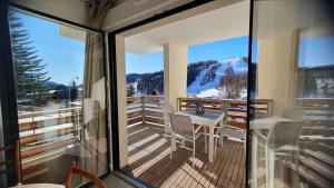 Cette chambre dispose d'un balcon avec une table et des chaises. dans l'établissement T3 STANDING CENTRE STATION VALBERG, à Valberg