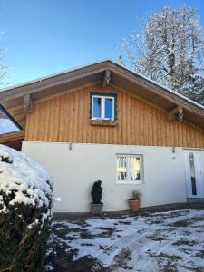 una casa cubierta de nieve delante de ella en Marienhof en Bad Tölz