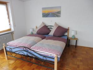 ein Bett mit zwei Kissen auf einem Zimmer in der Unterkunft Bobis Ferienwohnung in Wildpoldsried