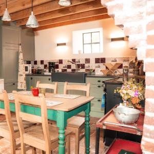 Lozerkasteel في Kruishoutem: مطبخ وغرفة طعام مع طاولة وكراسي