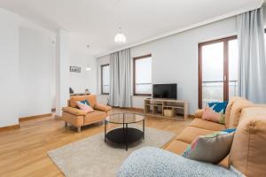 ein Wohnzimmer mit 2 Sofas und einem TV in der Unterkunft Tagore 3 by Homeprime in Warschau