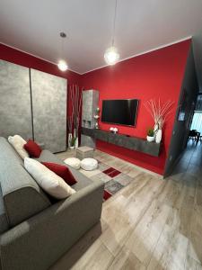 - un salon avec un canapé et un mur rouge dans l'établissement Tom & Ros House, à Casarano