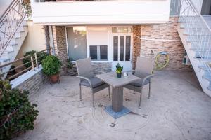 a patio with a table and chairs in front of a house at Leggero in Preveza
