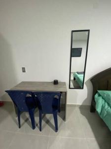 einen Tisch mit Stühlen und einen Spiegel im Zimmer in der Unterkunft Comfortable apartment very close to the airport in Cúcuta