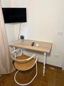uma secretária com uma cadeira e uma televisão na parede em Egadi Home em Favignana