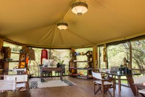 Zimmer mit einem Zelt mit Tischen und Stühlen in der Unterkunft Soroi Private Wing in Masai Mara