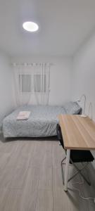 a bedroom with a bed and a desk and a table at Chinde Guesthouse in Lisbon +9 photos