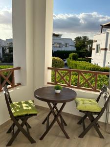 d'une table en bois et de deux chaises sur un balcon. dans l'établissement Sunterra Resort 01 bedroom Apt., à Charm el-Cheikh