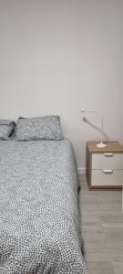 a bedroom with a bed and a night stand with a lamp at Chinde Guesthouse in Lisbon