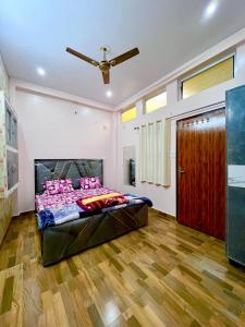 a bedroom with a bed with pink pillows on it at Trilok Residency - Dashashwamedh Varanasi in Varanasi