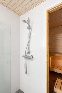 een douche in een badkamer met een douchekop bij Lumiapartment1 in Rovaniemi