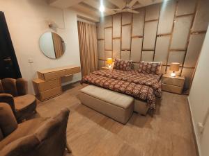 a bedroom with a bed and a chair and a mirror at Stay in Comforts in Islamabad