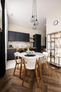 a kitchen with a white table and chairs at Designerski apartament w centrum Kazimierza in Krakow