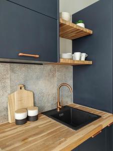 a kitchen with a sink and a counter top at Designerski apartament w centrum Kazimierza in Krakow
