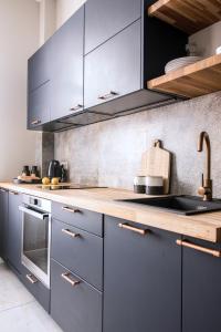 a kitchen with blue cabinets and wooden counter tops at Designerski apartament w centrum Kazimierza in Krakow